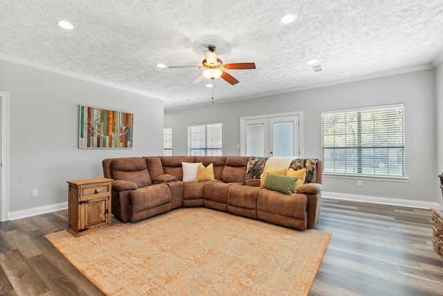 living room with ceiling fan, a textured ceiling, dark hardwood / wood-style flooring, and ornamental molding