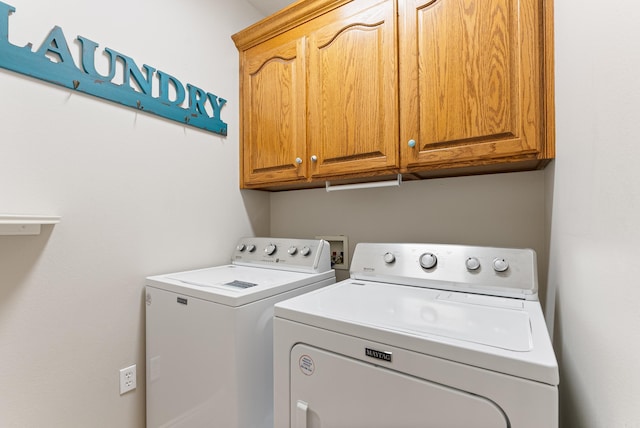 washroom with washer and clothes dryer and cabinets