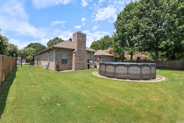 view of yard with a fenced in pool and cooling unit