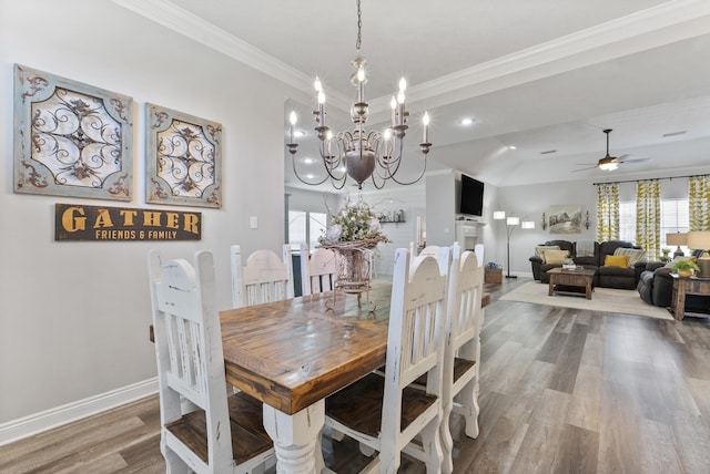 dining area featuring ornamental molding, ceiling fan with notable chandelier, and hardwood / wood-style flooring