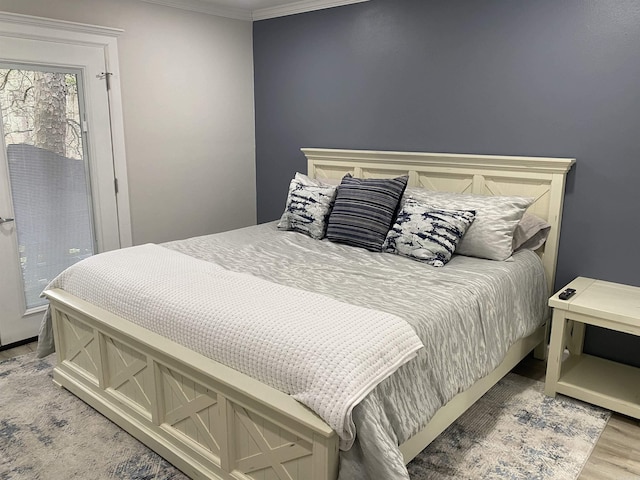bedroom with crown molding and light hardwood / wood-style floors