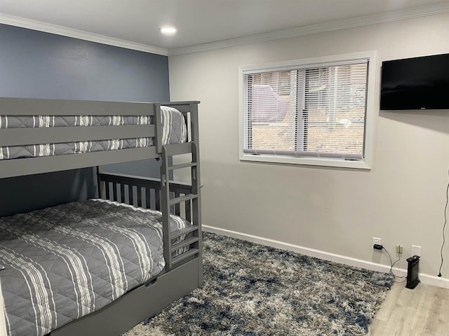 bedroom with crown molding and hardwood / wood-style flooring