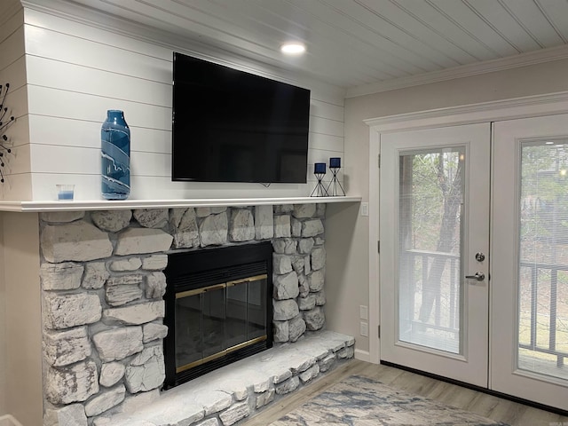 room details with hardwood / wood-style floors, wooden ceiling, a fireplace, french doors, and ornamental molding