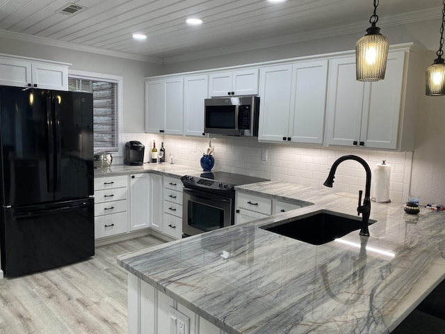kitchen with decorative light fixtures, sink, white cabinetry, appliances with stainless steel finishes, and light stone counters