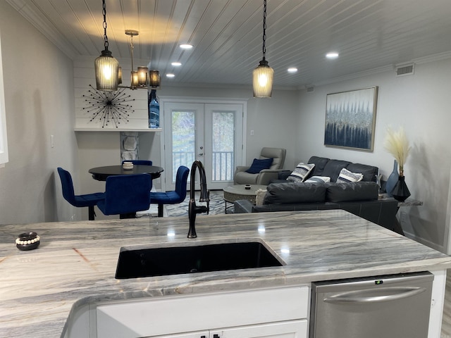 kitchen featuring light stone countertops, white cabinetry, pendant lighting, and sink