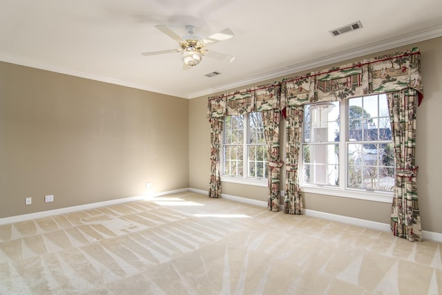 carpeted spare room with ceiling fan and crown molding