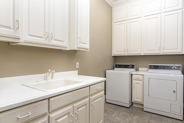 laundry room with cabinets, light tile patterned flooring, separate washer and dryer, and sink