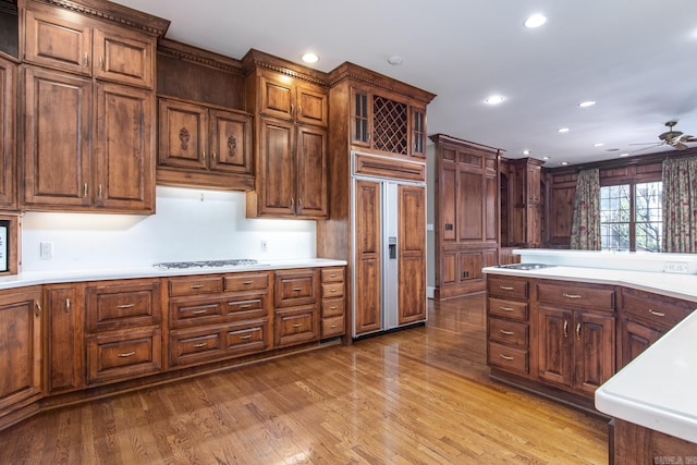 kitchen featuring light hardwood / wood-style floors, ceiling fan, gas stovetop, paneled built in fridge, and white gas cooktop