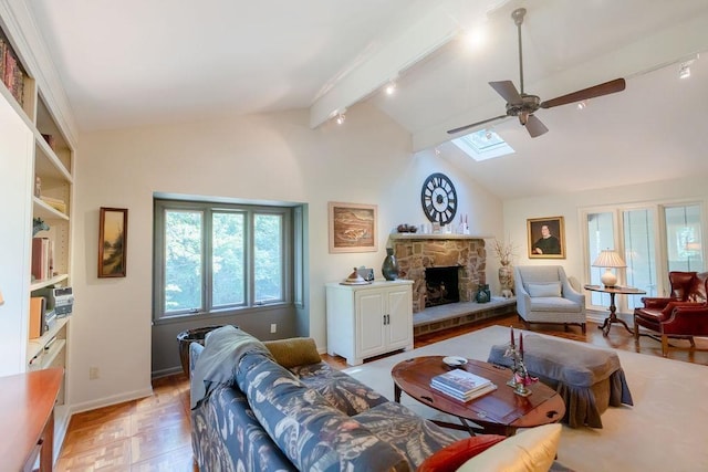 living room with vaulted ceiling with skylight, track lighting, light parquet flooring, a stone fireplace, and ceiling fan