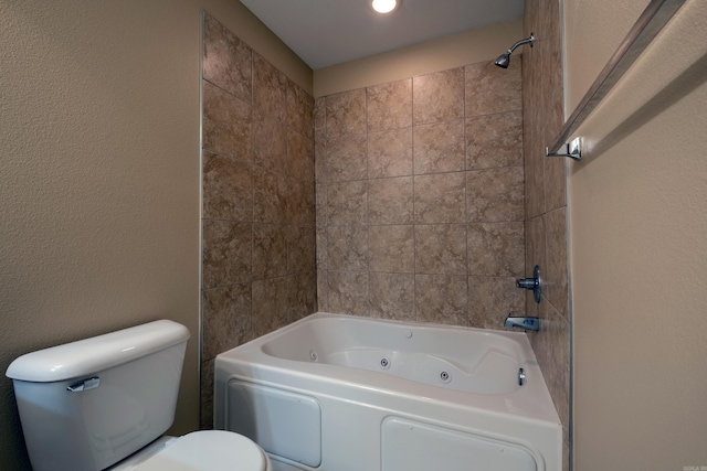 bathroom featuring toilet and tiled shower / bath