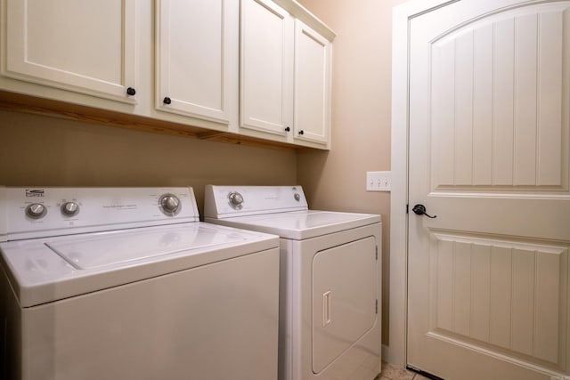 clothes washing area featuring independent washer and dryer and cabinets