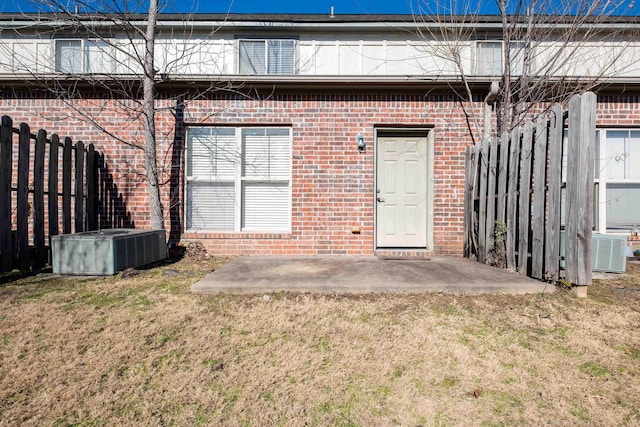 rear view of property featuring a patio area, a yard, and central AC