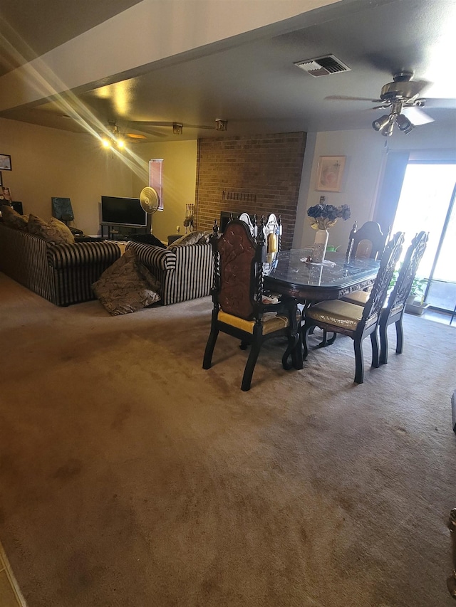 dining area with carpet, ceiling fan, and a fireplace