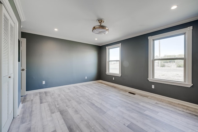 unfurnished bedroom featuring a closet, crown molding, and light hardwood / wood-style flooring