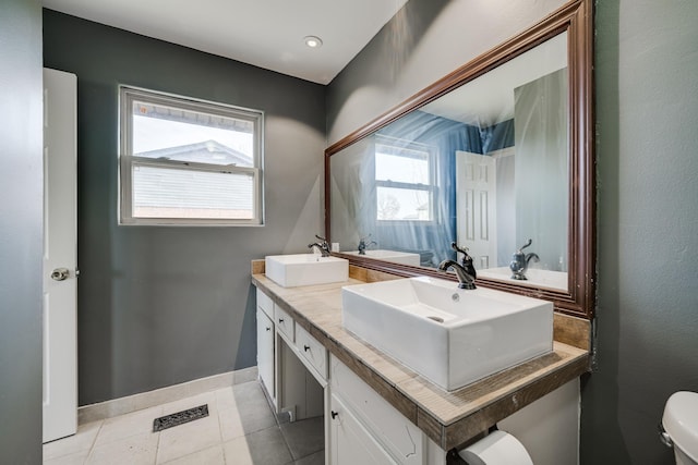 bathroom featuring toilet, vanity, and tile patterned flooring