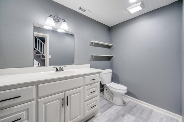 bathroom with toilet, hardwood / wood-style flooring, and vanity