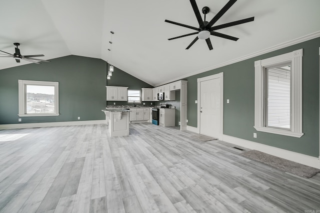 unfurnished living room with ceiling fan, lofted ceiling, ornamental molding, and light hardwood / wood-style flooring