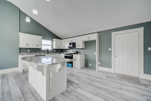 kitchen featuring a center island, decorative light fixtures, white cabinetry, light stone counters, and electric range