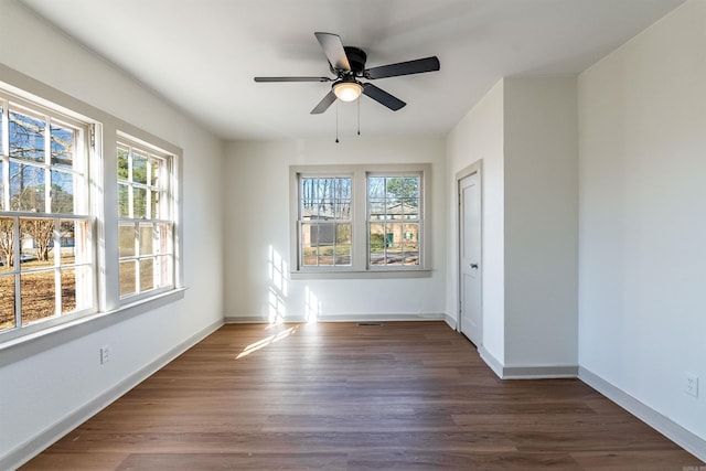 spare room featuring ceiling fan and dark wood-type flooring