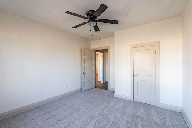 unfurnished bedroom with ceiling fan, a textured ceiling, and carpet flooring