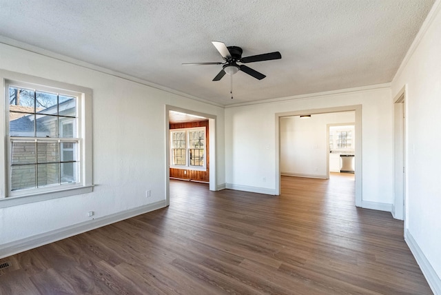 empty room with plenty of natural light, dark hardwood / wood-style flooring, and crown molding