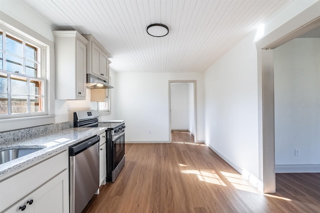 kitchen featuring white cabinetry, wood ceiling, appliances with stainless steel finishes, light wood-type flooring, and light stone counters