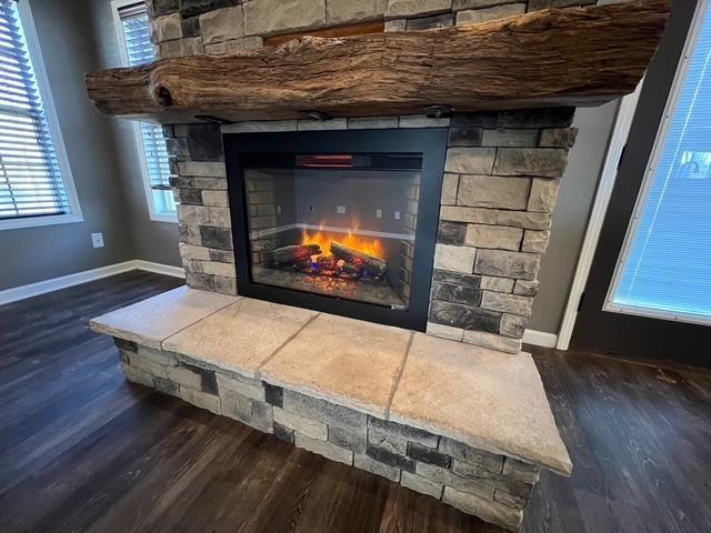 interior details with hardwood / wood-style floors and a stone fireplace