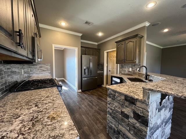 kitchen featuring stainless steel appliances, sink, decorative backsplash, and light stone countertops