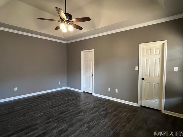 spare room featuring vaulted ceiling, ceiling fan, dark hardwood / wood-style flooring, and crown molding