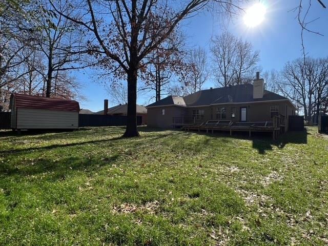 view of yard featuring a wooden deck and a storage unit