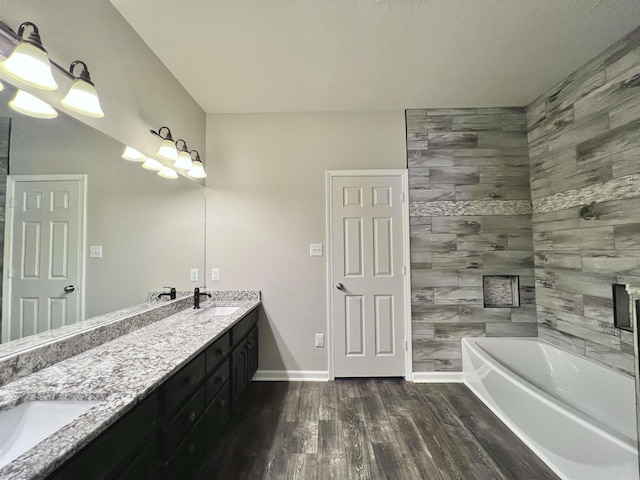 4112 Stephanie Ln, Jonesboro, AR 72401 - bathroom featuring double vanity, a sink, wood finished floors, and a tub to relax in