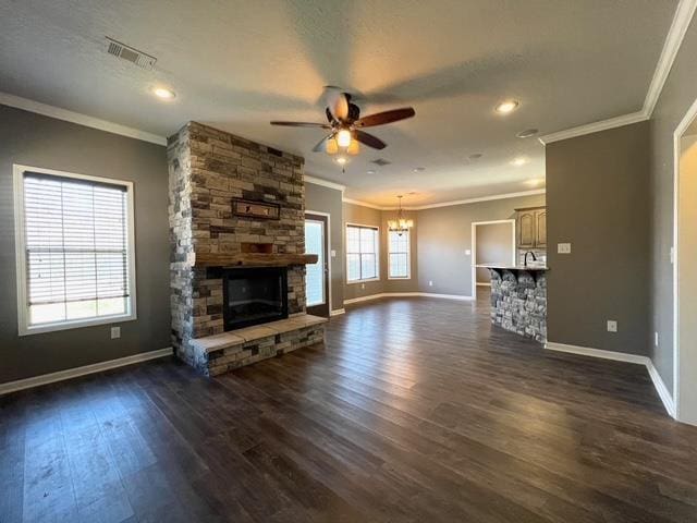 unfurnished living room featuring dark hardwood / wood-style floors, crown molding, and a stone fireplace