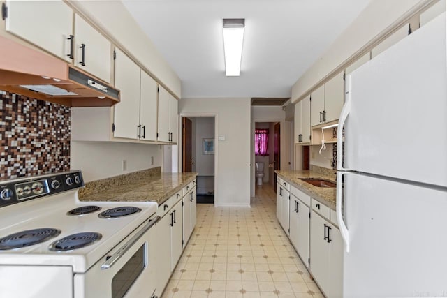 kitchen with light stone countertops, backsplash, white appliances, and white cabinets