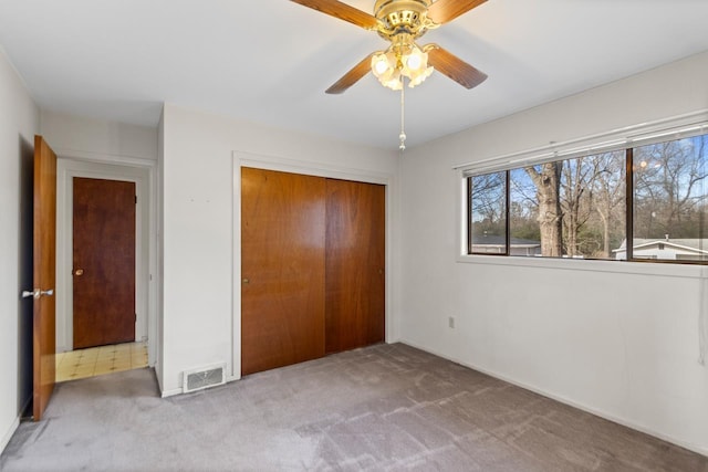 unfurnished bedroom with ceiling fan, carpet, and a closet