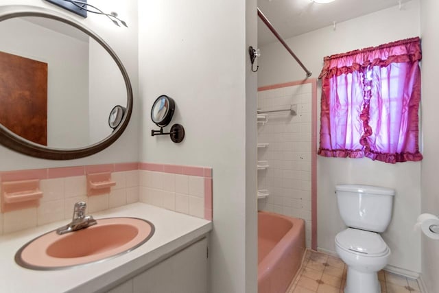 full bathroom featuring toilet, tiled shower / bath, and sink