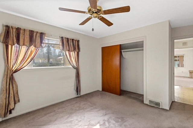 unfurnished bedroom with ceiling fan, a closet, and light carpet