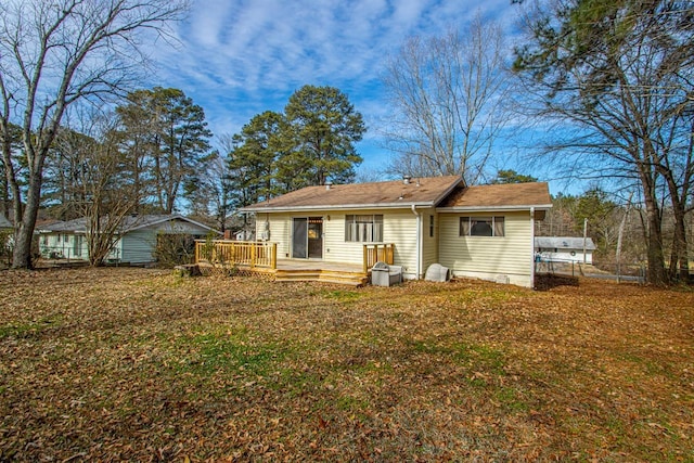 back of property featuring a wooden deck and a yard