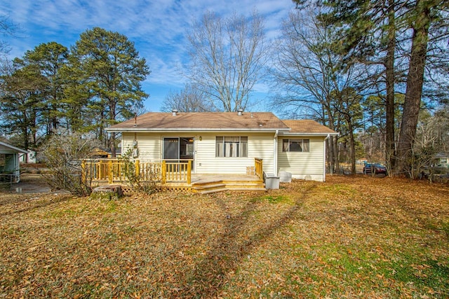 rear view of property with a deck and a lawn