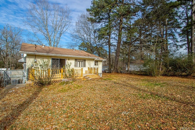 rear view of property with a lawn and a deck