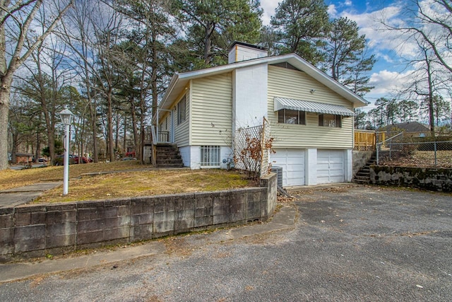 view of home's exterior with a garage and central AC