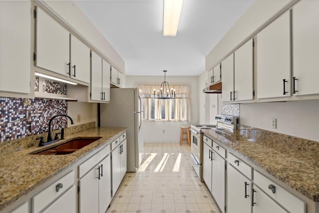 kitchen with electric stove, pendant lighting, sink, white cabinetry, and a chandelier