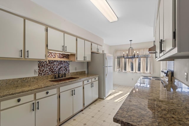 kitchen with decorative light fixtures, white cabinetry, white fridge, sink, and electric stove