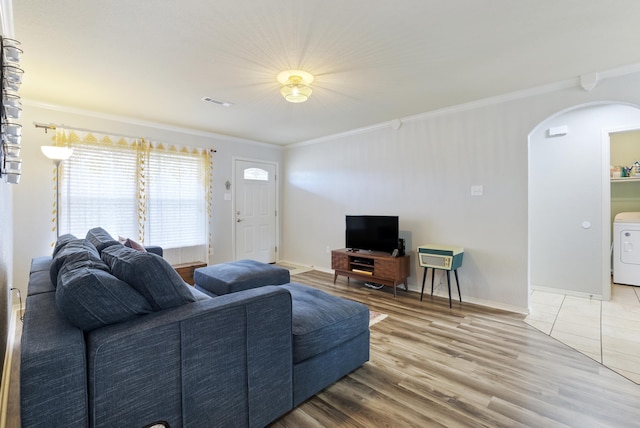 living room with hardwood / wood-style flooring, washer / dryer, and ornamental molding