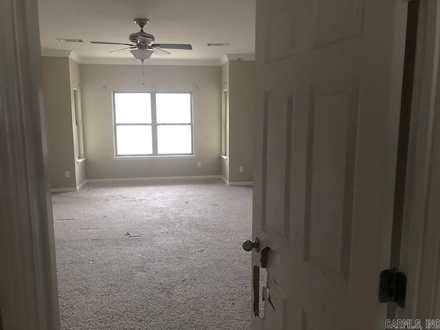 carpeted spare room featuring ceiling fan and ornamental molding