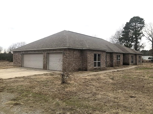 view of home's exterior with a garage and a lawn