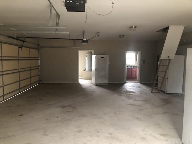 garage with fridge, white refrigerator, and a garage door opener