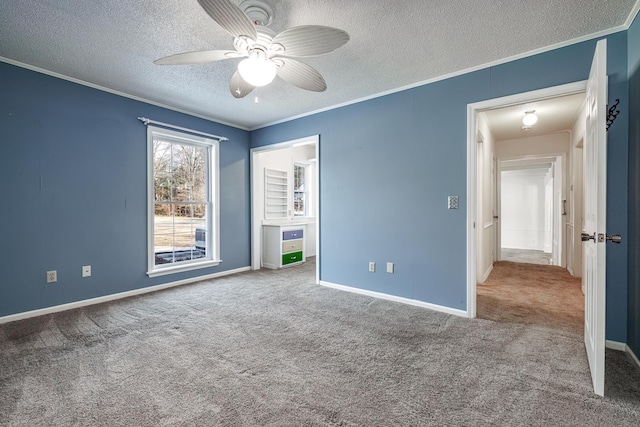 unfurnished bedroom with ceiling fan, a textured ceiling, ornamental molding, and carpet flooring