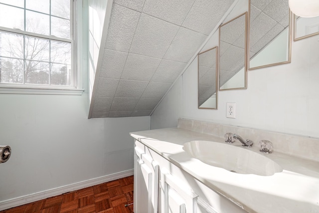 bathroom with parquet floors, lofted ceiling, and vanity