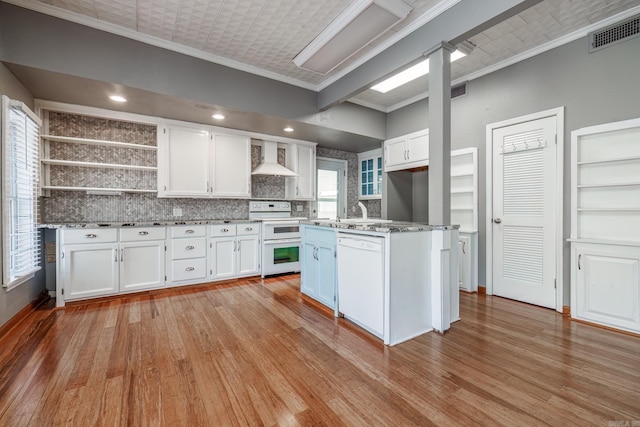 kitchen with double oven range, white cabinetry, dishwasher, and wall chimney range hood