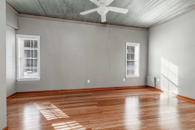 empty room with ceiling fan, ornamental molding, and light hardwood / wood-style floors